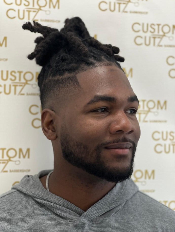 Twists on top with a taper fade and lined beard